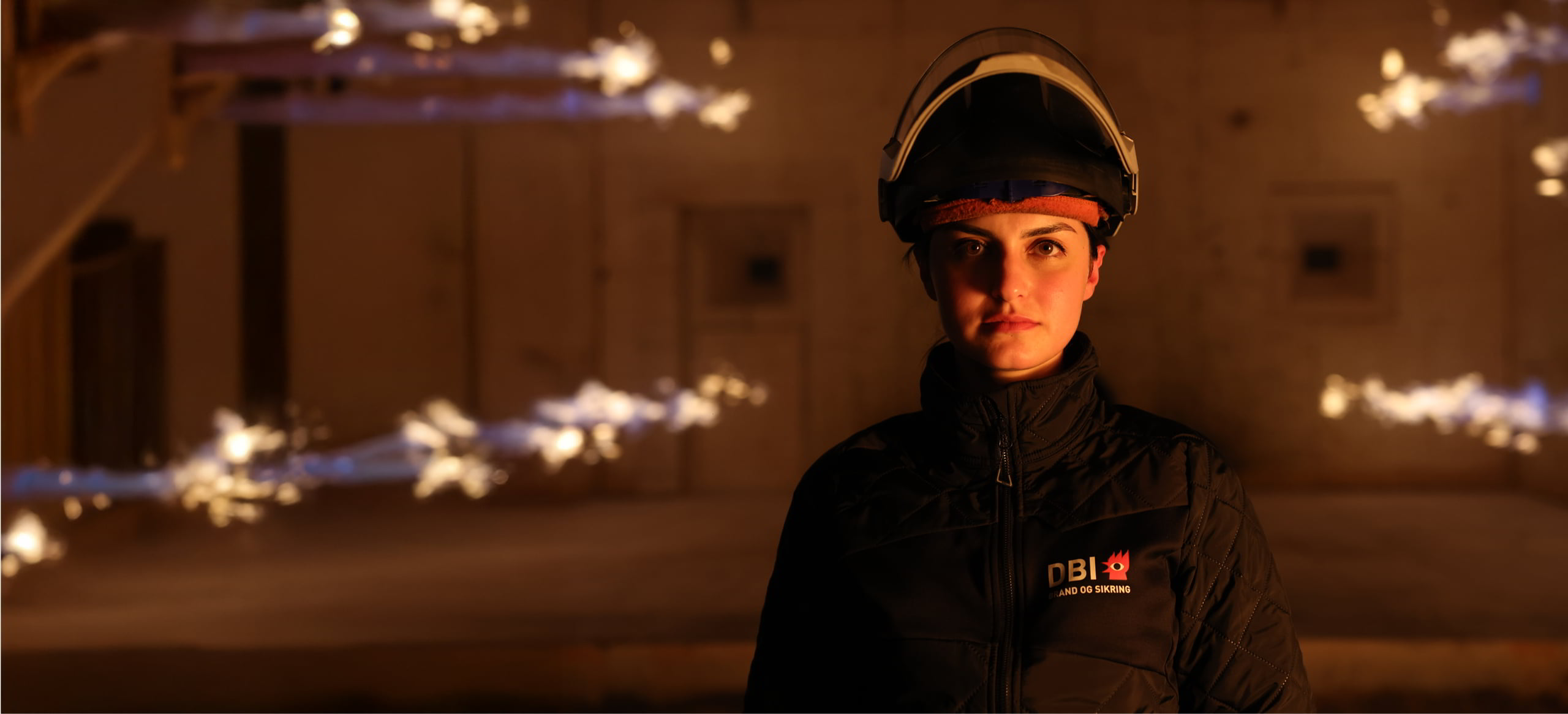 DBI employee in a test hall surrounded by controlled flames.