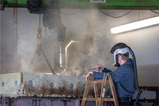 Technician working at a smoke-filled test setup in DBI’s fire laboratory.